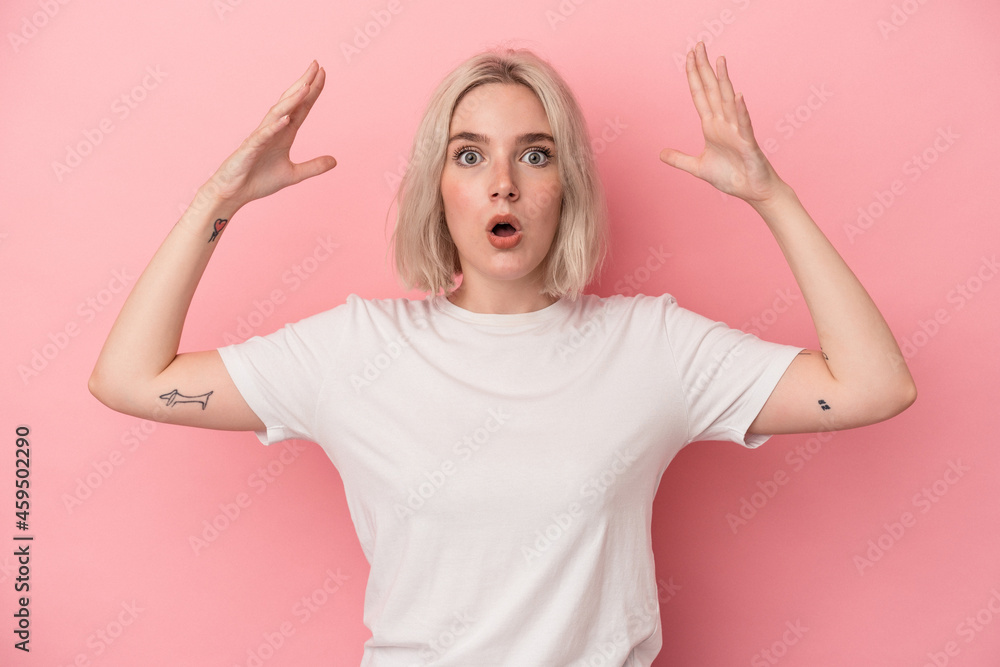 Young caucasian woman isolated on pink background celebrating a victory or success, he is surprised and shocked. Young caucasian woman isolated on pink background celebrating a victory or success, he is surprised and shocked.