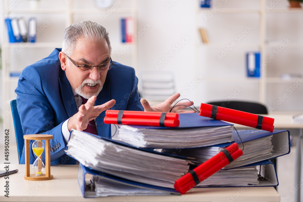 Old male employee with dynamite in the office Old male employee with dynamite in the office