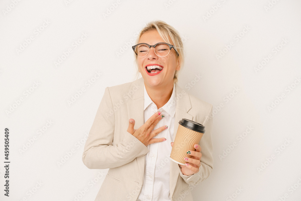 Young business Russian woman holding take away coffee isolated on white background laughs out loudly keeping hand on chest. Young business Russian woman holding take away coffee isolated on white background laughs out loudly keeping hand on chest.