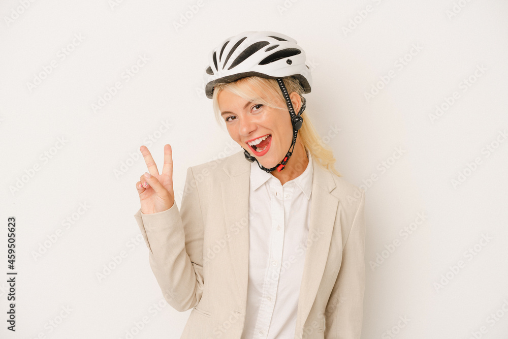 Young business Russian woman holding bike helmet isolated on white background joyful and carefree showing a peace symbol with fingers. Young business Russian woman holding bike helmet isolated on white background joyful and carefree showing a peace symbol with fingers.