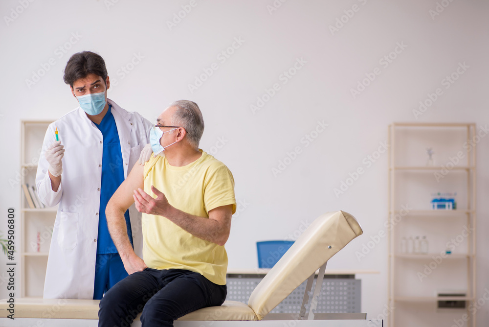 Fototapeta premium Old male patient visting young male doctor in vaccination concep