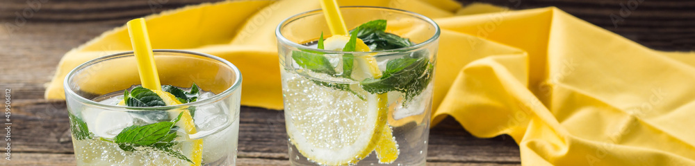 banner of Lemonade or mojito cocktail with lemon and mint with ice. Cold summer refreshing drink decorated with yellow napkin banner of Lemonade or mojito cocktail with lemon and mint with ice. Cold summer refreshing drink decorated with yellow napkin