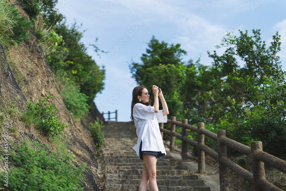 Naklejka premium 海で写真を撮るカメラ女子