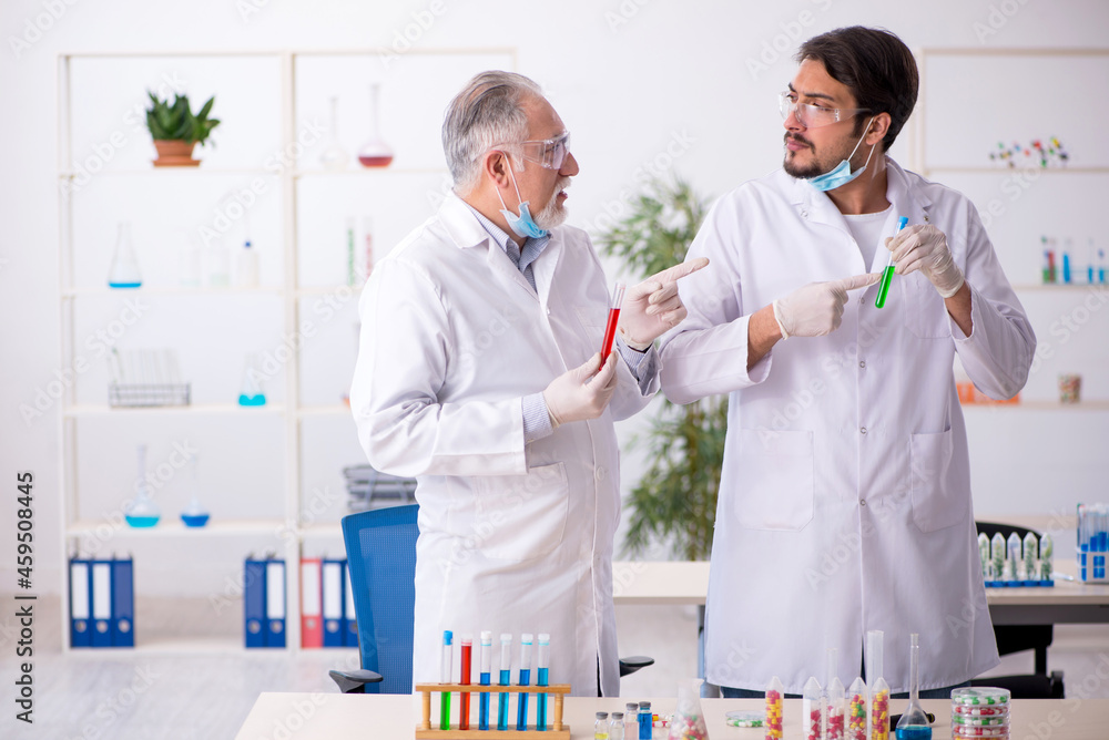 Two male chemists in drugs synthesis concept at the lab Two male chemists in drugs synthesis concept at the lab