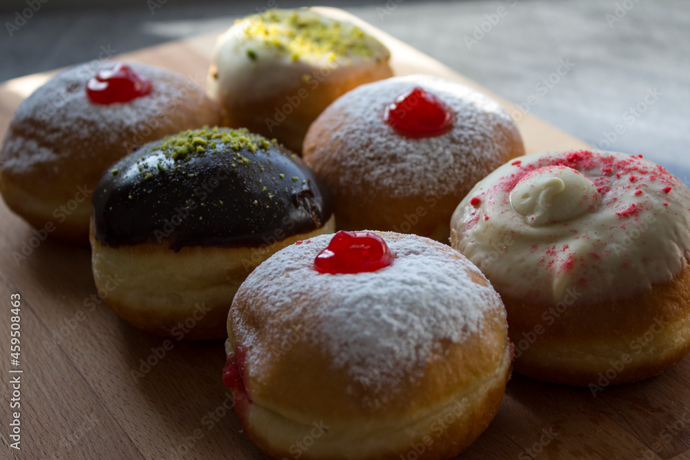 Doughnuts with different types of fillings close up photo. Authentic Israeli doughnut - sufgania. Symbols of Hanukkah fest.