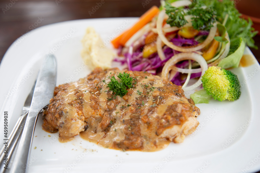Chicken Steak with Sauce and vegetables in a white plate ready to serve Chicken Steak with Sauce and vegetables in a white plate ready to serve