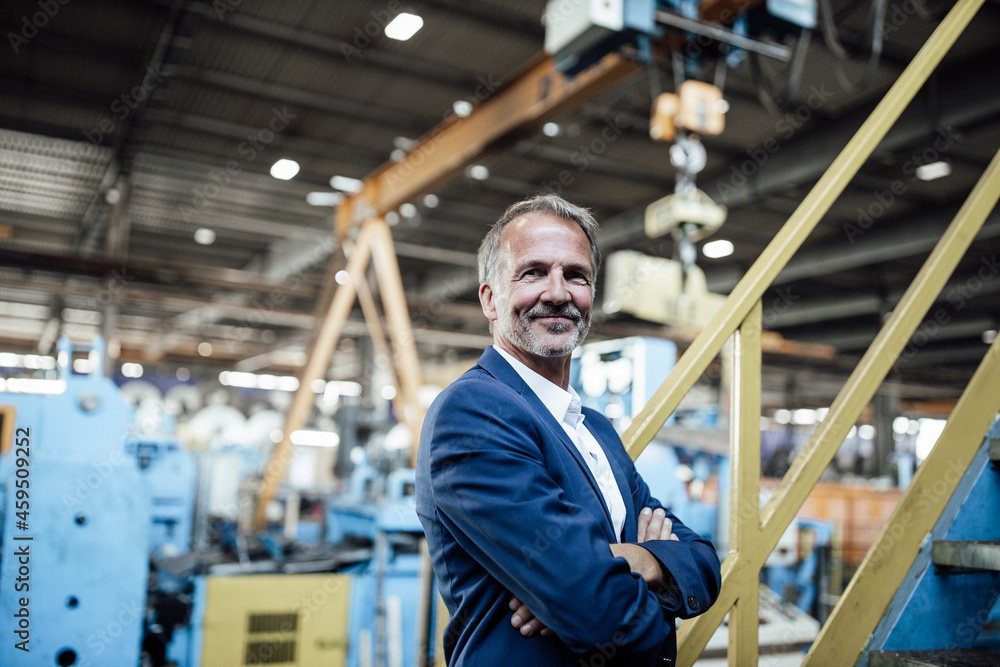 Male professional with arms crossed standing in steel mill Male professional with arms crossed standing in steel mill