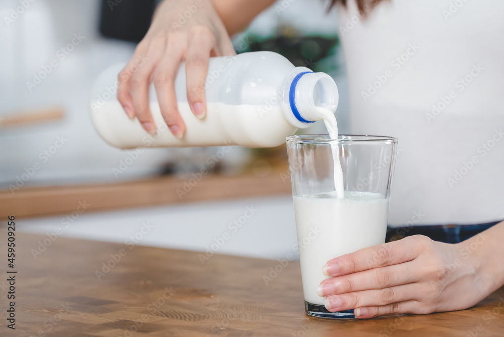 Close up hands woman pour pasteurized. milk to glass. Close up hands woman pour pasteurized. milk to glass.