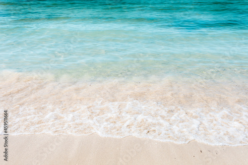 Crystal clear sea water and white sand. Waves on the coast. Caribbean sea and tropical holidays. Holiday wallpaper.