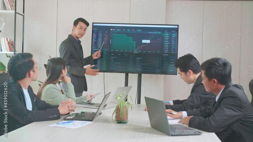Young Asian Businessman Presentation To His Business Colleagues About Financial Chart Trading Online Investment Data On Tv Screen, Meeting Room
