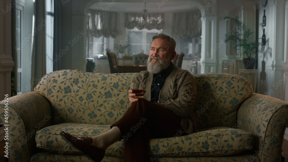 Old aged man relaxing with glass whiskey. Rich man thinking retirement life Old aged man relaxing with glass whiskey. Rich man thinking retirement life