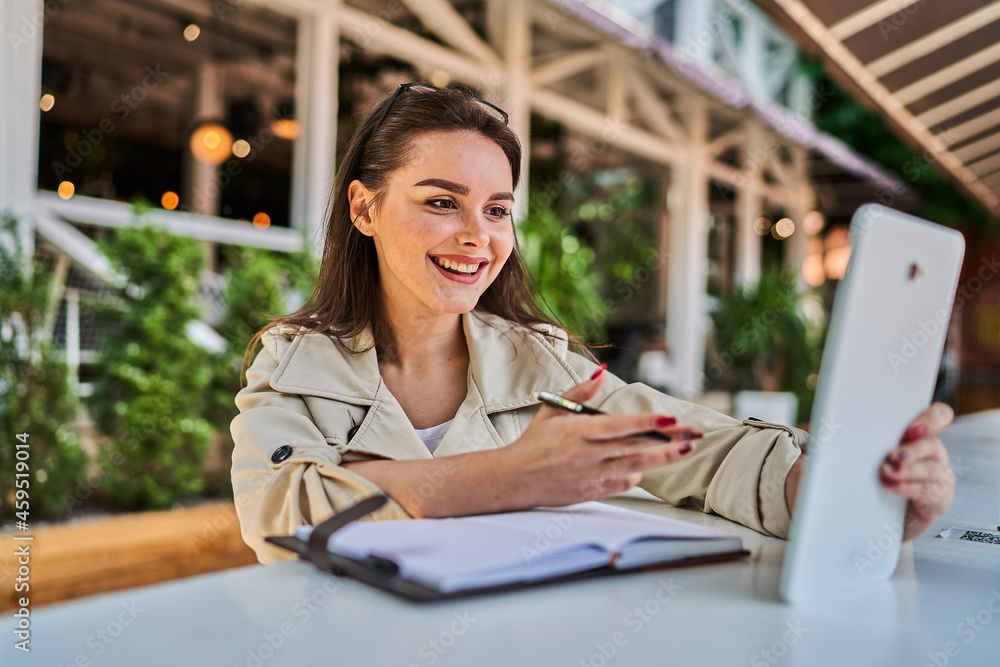 Preety woman speaking by video call with tablet outdoors. Preety woman speaking by video call with tablet outdoors.
