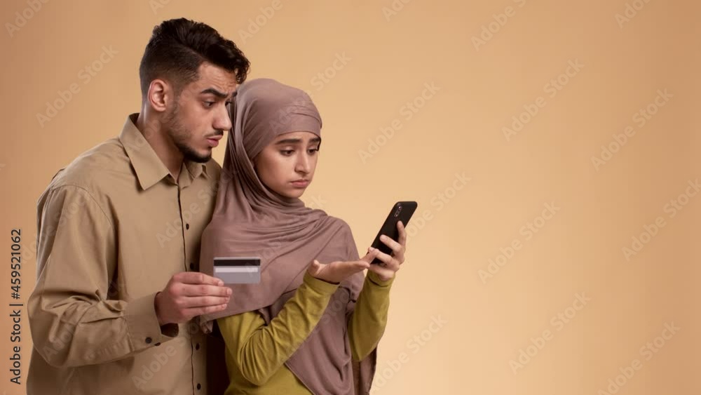 Muslim Couple Having Problem With Phone And Credit Card, Studio Muslim Couple Having Problem With Phone And Credit Card, Studio