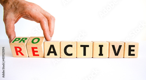 Reactive or proactive symbol. Businessman turns wooden cubes and changes the word reactive to proactive. Business and reactive or proactive concept. Beautiful white background, copy space.