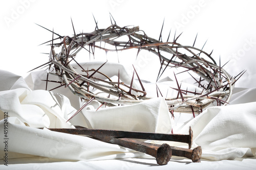 Fototapete Crown of thorns and nails on a white fabric - the symbols of crucifixion