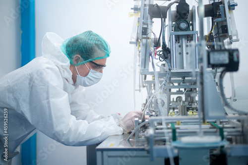 Workers producing surgical mask in modern factory  Covid-19 protection and medical concept.