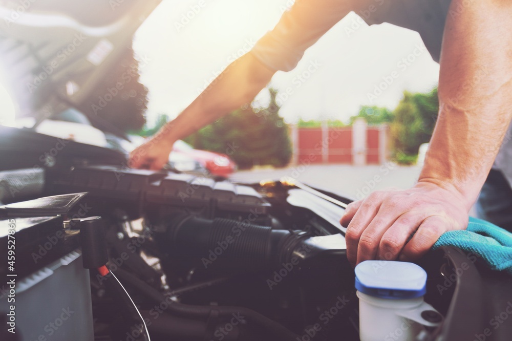 mechanic inspects the expansion tank with antifreeze. Сar's radiator system. mechanic inspects the expansion tank with antifreeze. Сar's radiator system.