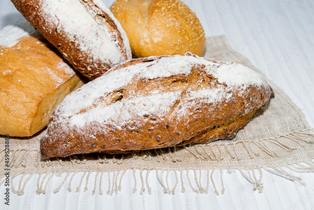 different bread round baguette isolated on white wood background, rustic crusty bun top view, food and drink concept.