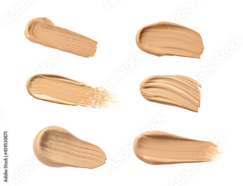 Set with different shades of liquid skin foundation on white background, top view