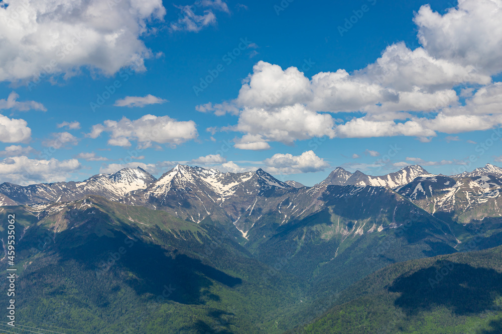 Spring mountain landscape with green mountains and snow peaks. Ski resort Krasnaya Polyana (Red Meadow). Sochi. Russia.