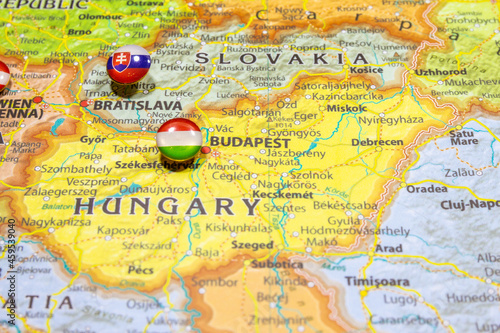 National flag Hungary pinned on political Europe map. Macro Close up picture on a colorful and blurry world atlas with capital country - Budapest. Push pin marker of destination.