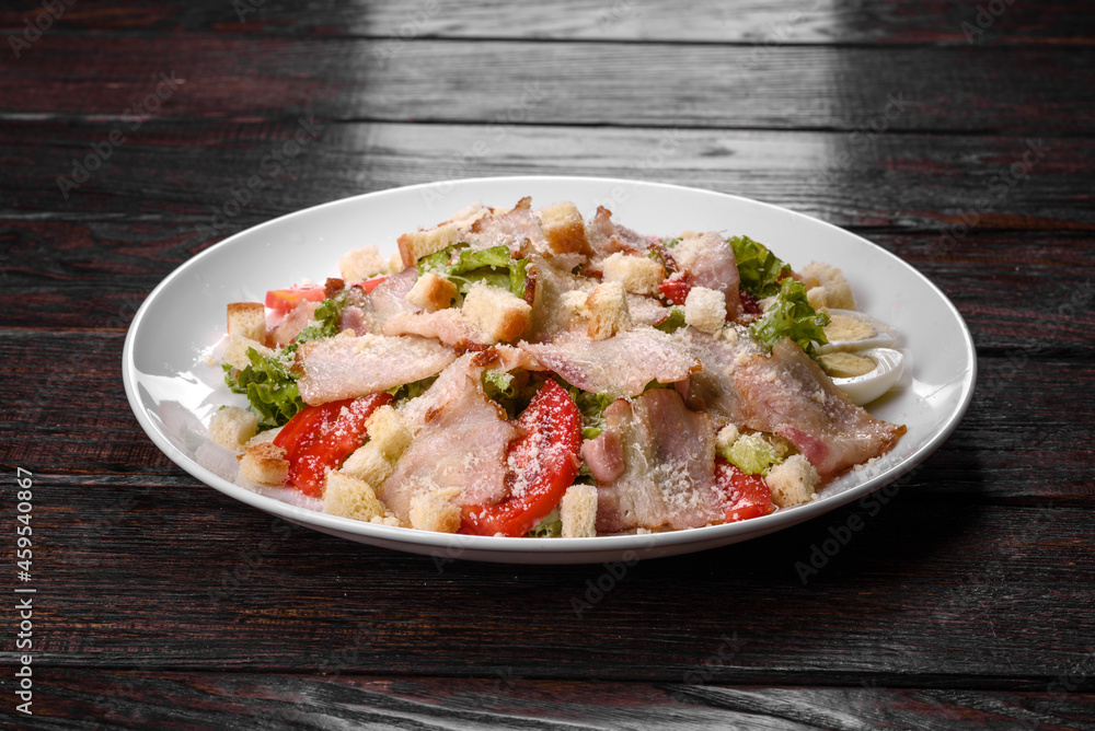 Delicious fresh salad with bacon and tomatoes with spices and greens Delicious fresh salad with bacon and tomatoes with spices and greens