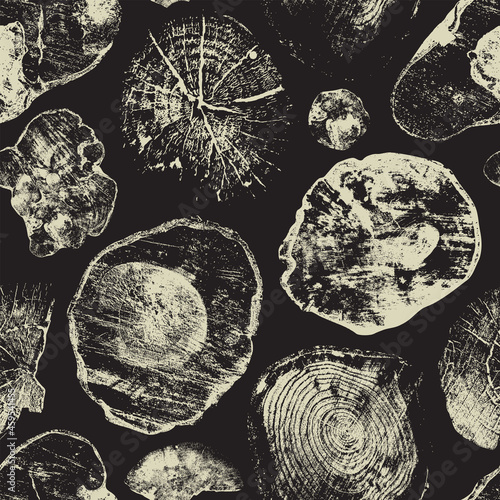 Abstract seamless pattern with old wood saw cuts on a black backdrop. Wooden texture with annual rings and cross sections of old trees. Monochrome vector background with various shaped stumps