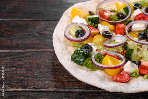 Tasty fresh Greek salad on a pita cooked for a festive table