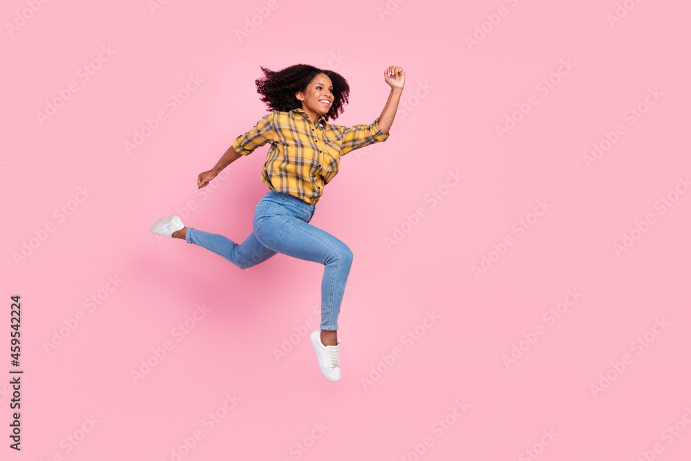 Photo of sweet cute dark skin woman dressed plaid shirt smiling jumping high running fast isolated pink color background