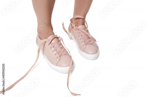 untied pink sneakers on white background