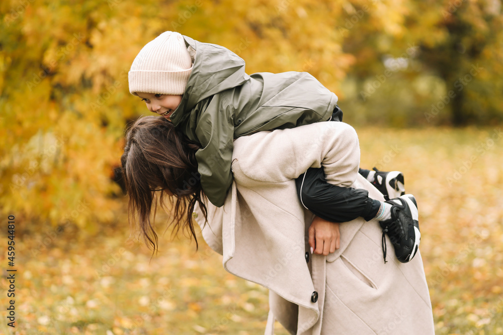 Happy cheerful mother and a small child son in warm clothes walking among plants in an autumn park in nature in fall outdoor, selective focus Happy cheerful mother and a small child son in warm clothes walking among plants in an autumn park in nature in fall outdoor, selective focus