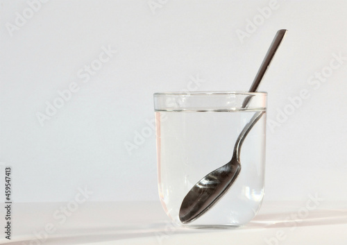 optical effect with a glass of water and a silver spoon