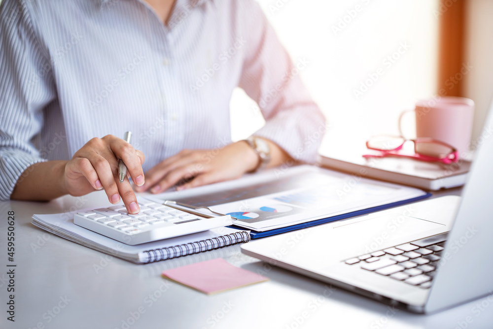 businessman or accountant who are using a calculator to calculate business data Accounting documents and laptop computer at the office business idea businessman or accountant who are using a calculator to calculate business data Accounting documents and laptop computer at the office business idea