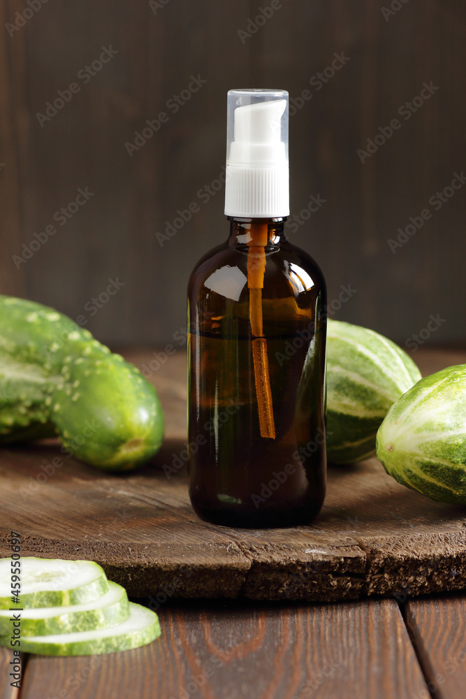 Cucumber herbal essential water or oil, amber glass bottle with natural skincare spray extract, closeup, organic cosmetics and wellness concept Cucumber herbal essential water or oil, amber glass bottle with natural skincare spray extract, closeup, organic cosmetics and wellness concept
