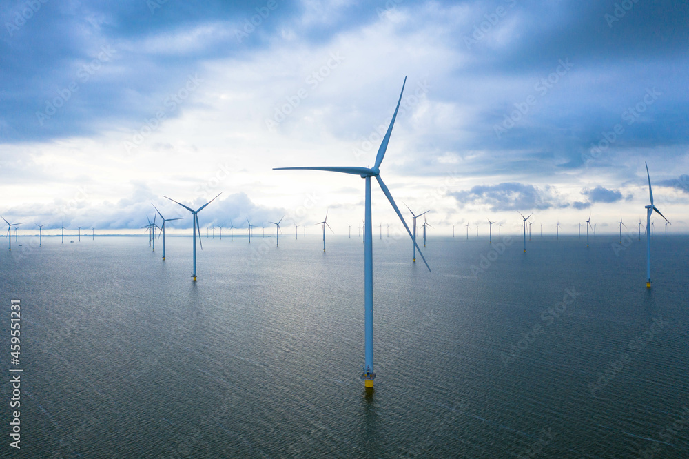 Aerial view, Enormous windmills stand in the sea along a dutch sea. Fryslân wind farm, the largest inland wind farm in the world. Friesland, Ijsselmeer, Breezanddijk, Netherlands