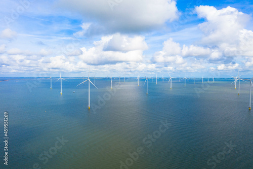 Aerial view, Enormous windmills stand in the sea along a dutch sea. Fryslân wind farm, the largest inland wind farm in the world. Friesland, Ijsselmeer, Breezanddijk, Netherlands photo