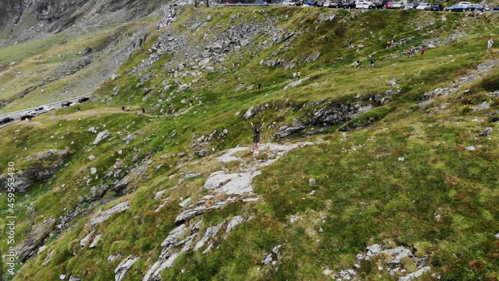 Happy girl in a dress whirls on the top of the mountains on the Transfagaras road in Romania Happy girl in a dress whirls on the top of the mountains on the Transfagaras road in Romania