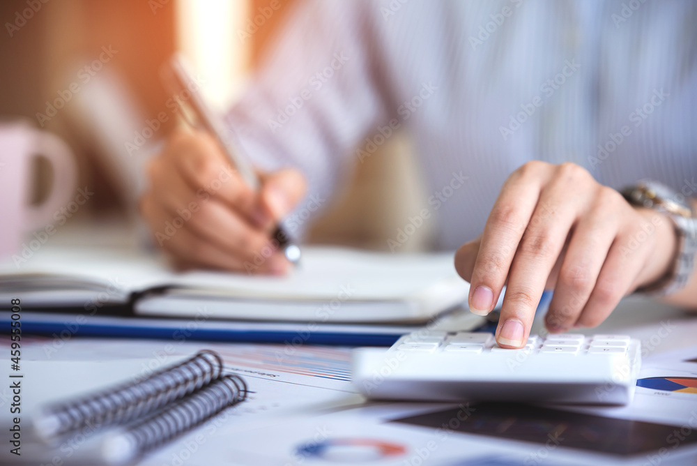 business woman or accountant who are using a calculator to calculate business data Accounting documents and laptop computer at the office business idea business woman or accountant who are using a calculator to calculate business data Accounting documents and laptop computer at the office business idea