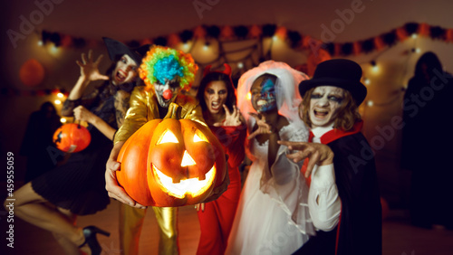 фотографія Adult male and female friends with scary makeup on faces having fun at costume party at home