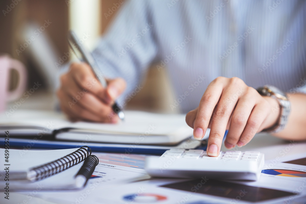 business woman or accountant who are using a calculator to calculate business data Accounting documents and laptop computer at the office business idea business woman or accountant who are using a calculator to calculate business data Accounting documents and laptop computer at the office business idea