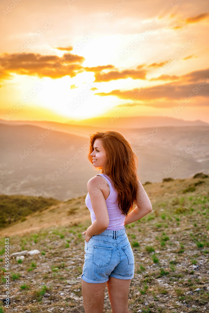 Beautiful slender woman on top of a mountain at sunset. Amazing landscape with a gradient of mountains. The concept of sports and active life. Beautiful slender woman on top of a mountain at sunset. Amazing landscape with a gradient of mountains. The concept of sports and active life.