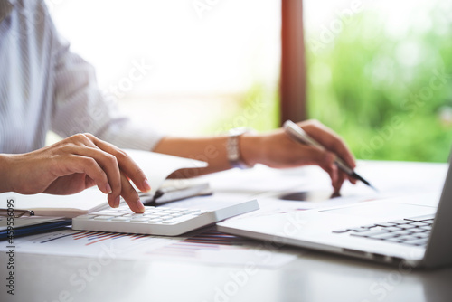 businessman or accountant who are using a calculator to calculate business data Accounting documents and laptop computer at the office business idea