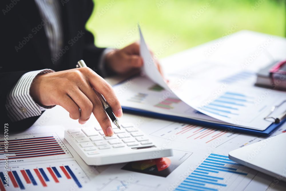 A young woman's hand presses a calculator to determine and summarize the cost of mortgage home loans for refinancing plans, lifestyle concepts. A young woman's hand presses a calculator to determine and summarize the cost of mortgage home loans for refinancing plans, lifestyle concepts.