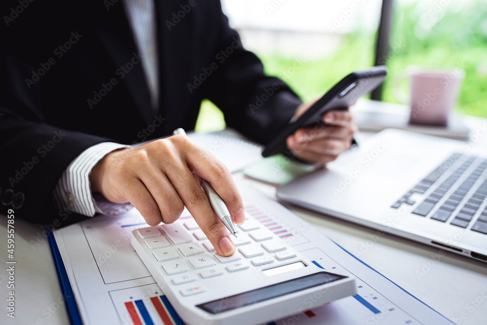 A young woman's hand presses a calculator to determine and summarize the cost of mortgage home loans for refinancing plans, lifestyle concepts. A young woman's hand presses a calculator to determine and summarize the cost of mortgage home loans for refinancing plans, lifestyle concepts.