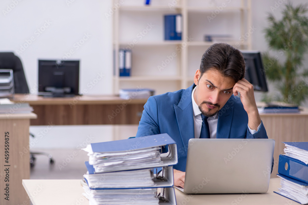 Young businessman employee unhappy with excessive work in the of Young businessman employee unhappy with excessive work in the of