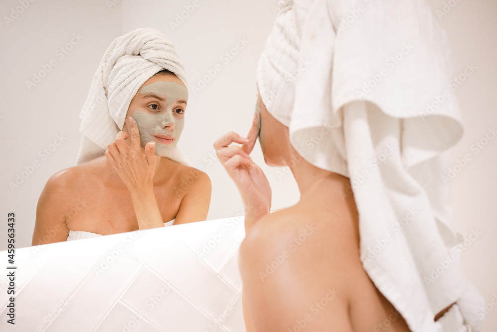 young white woman applying green clay mask bathroom mirror anti acne anti aging spots signs of age oily skin treatment after shower self care skin care young adult cosmetics plump toned spotless skin young white woman applying green clay mask bathroom mirror anti acne anti aging spots signs of age oily skin treatment after shower self care skin care young adult cosmetics plump toned spotless skin