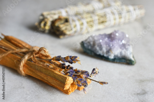 A close up image of a smudge sticks with dried lavender and amethyst crystals.  photo