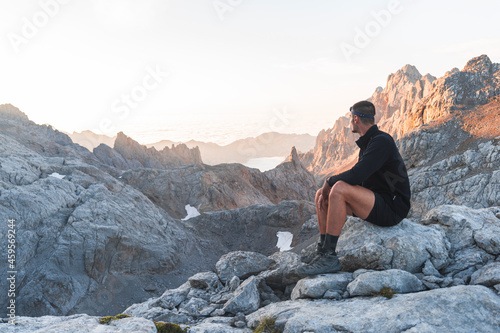 Male tourist looking at Picos de Europe mountain ranges at sunrise, Cantabria, Spain photo