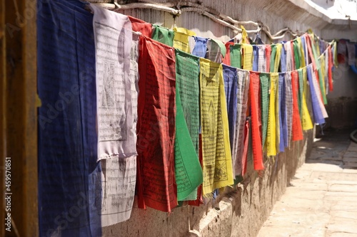 Traditional nepalese flags hanging on a wall. © Kevin