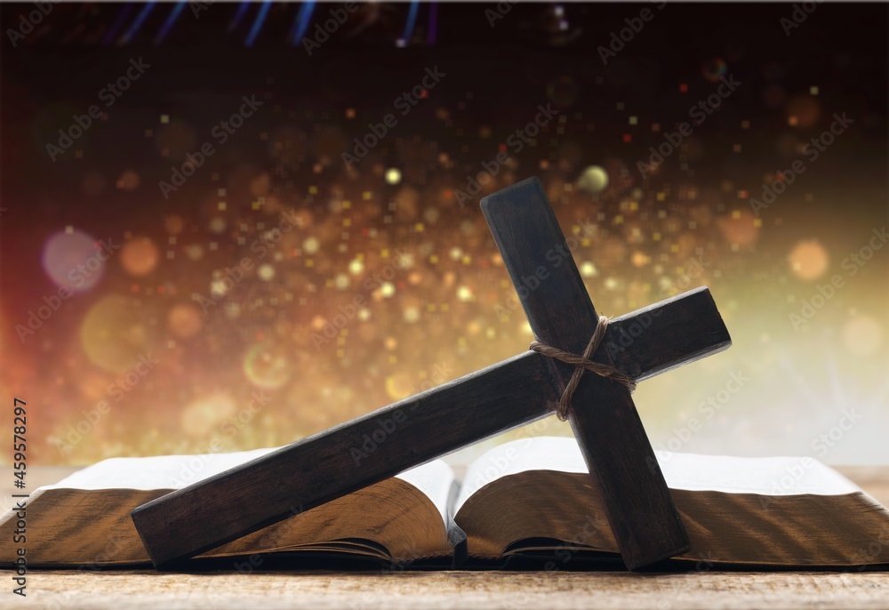 Holy Bible with wooden cross on the bokeh background